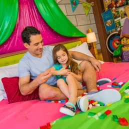 Dad and daughter build with LEGO in a princess themed room