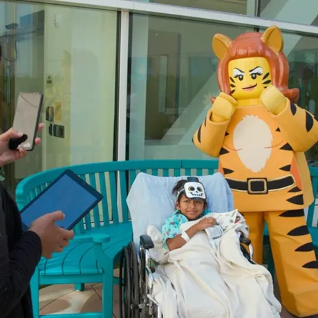 Tiger Lady posing with child from Rady Children's