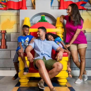 Family sitting around LEGO throne at LEGOLAND Castle Hotel