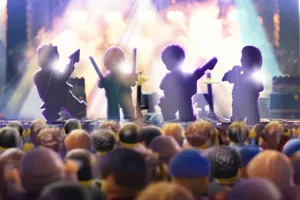 Colorful scene from the LEGO Festival event at LEGOLAND California, featuring LEGO minifigures on the main stage for a playful 'Battle of the Bands' performance. The stage is decorated with vibrant LEGO bricks, musical instruments, and lights, while various minifigures rock out in different band outfits, surrounded by cheering LEGO fans.