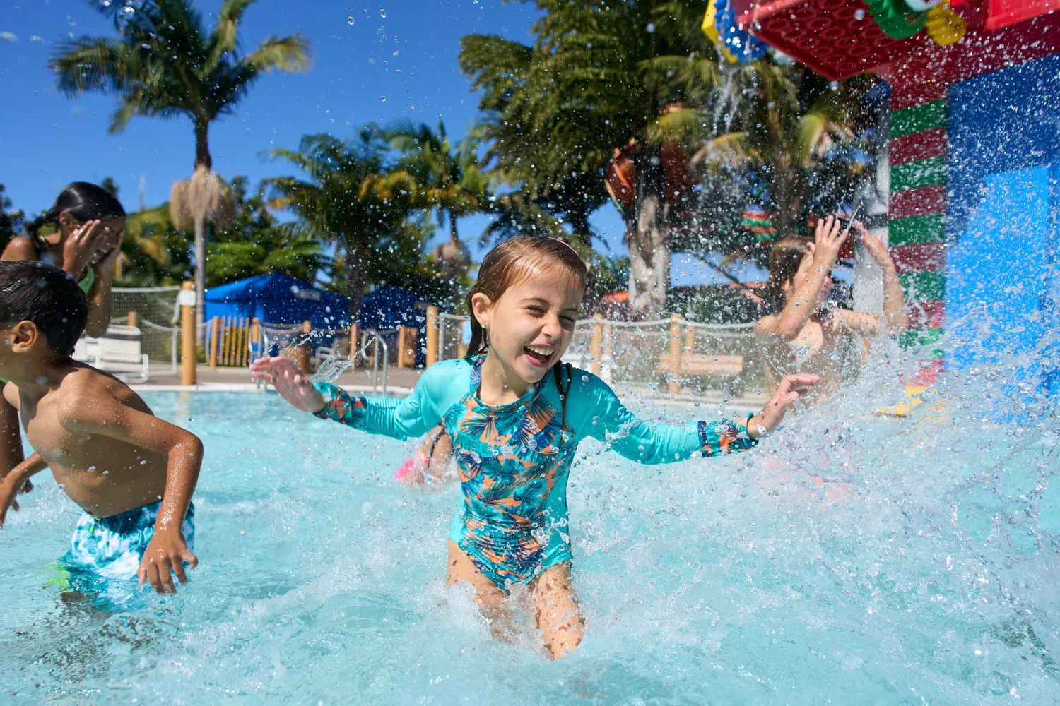 Girl splashing in the water with a big smile at the Duplo Splash Pad