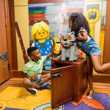 Kids open the treasure hunt chest in a wizard themed room