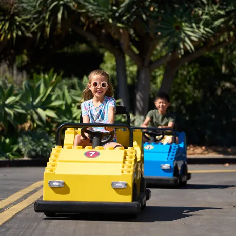 Girl in sunglasses rides yellow car on Driving School