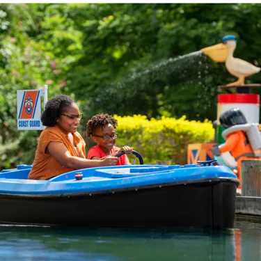 Mom and child driving a boat on Skipper School