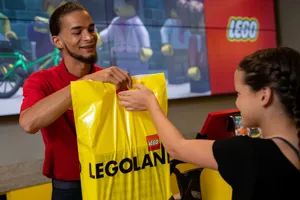 Man giving gift bag to LEGOLAND California guest